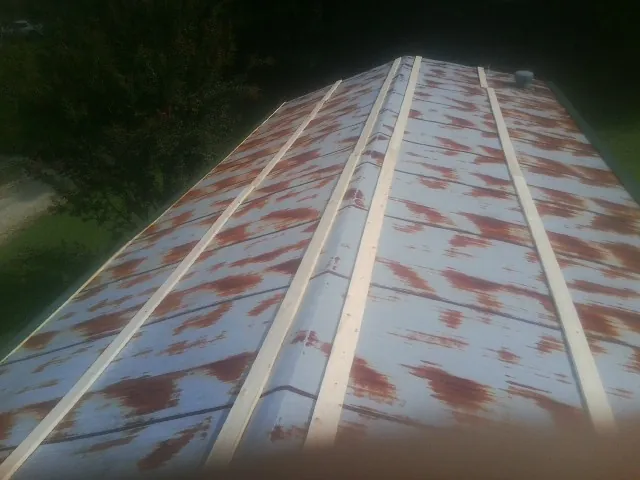 Rusted metal roof panels with new wood purlins before replacement — Storm Damage Roof Repair in Jamesport by Roofing Brothers